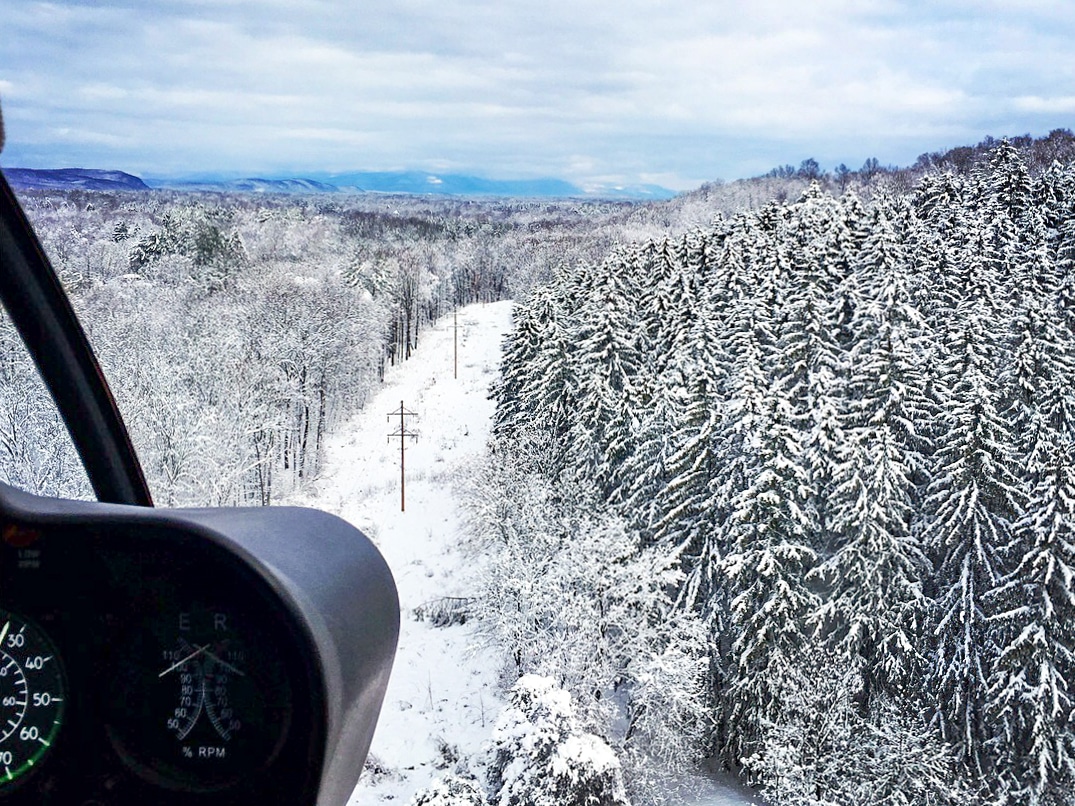 aerial view of snow-covered trees and mountains during a winter helicopter tour