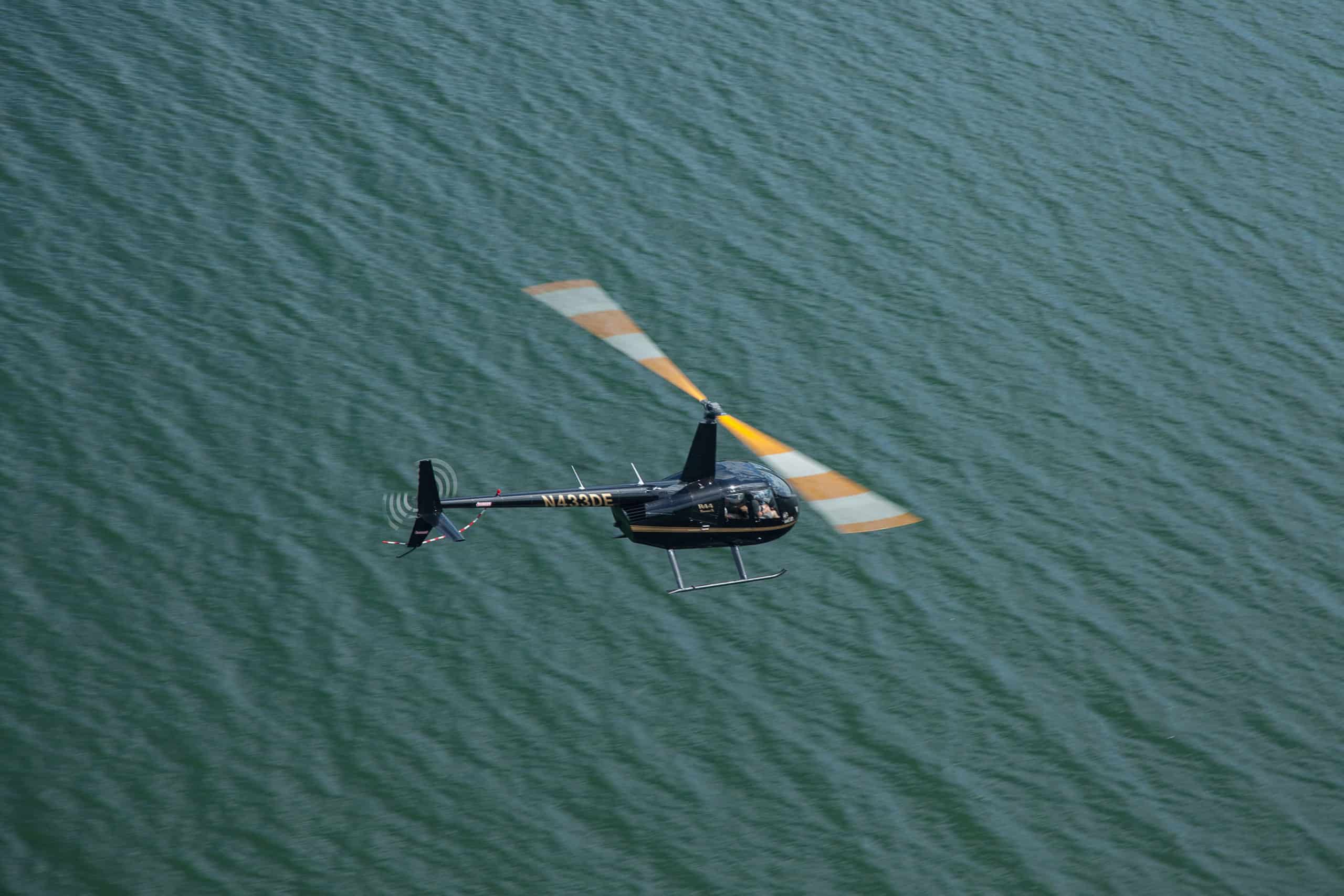 aerial view of R44 helicopter flying over water