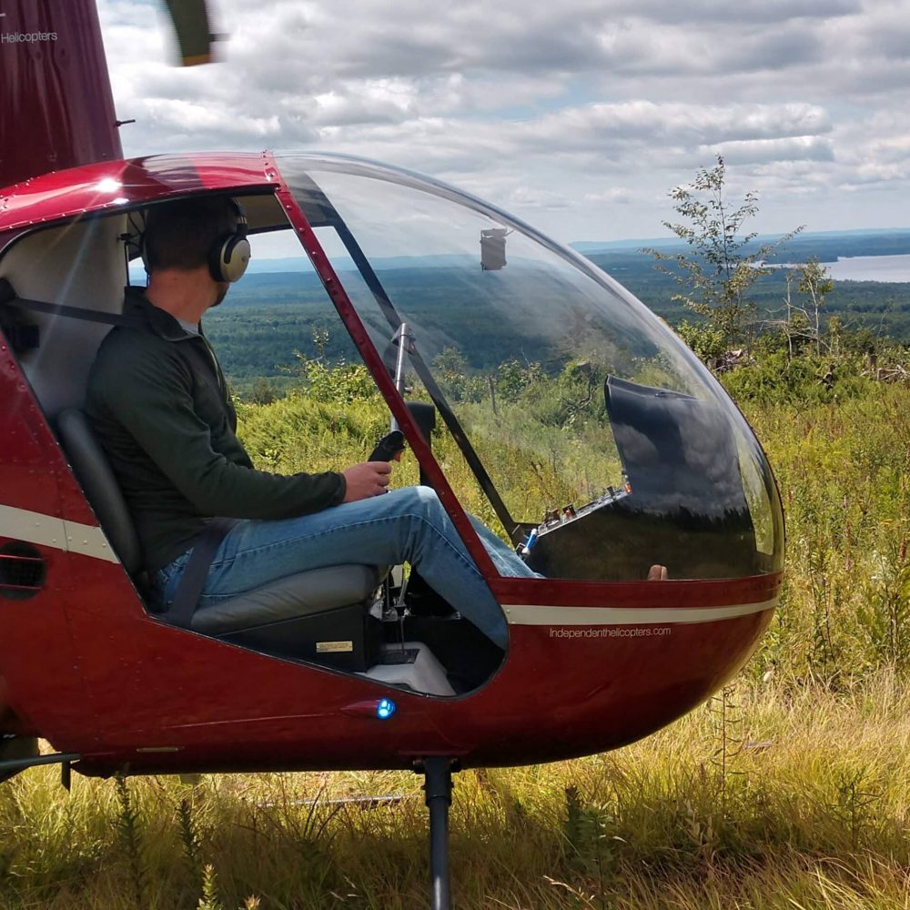 helicopter pilot with scenic landscape in background